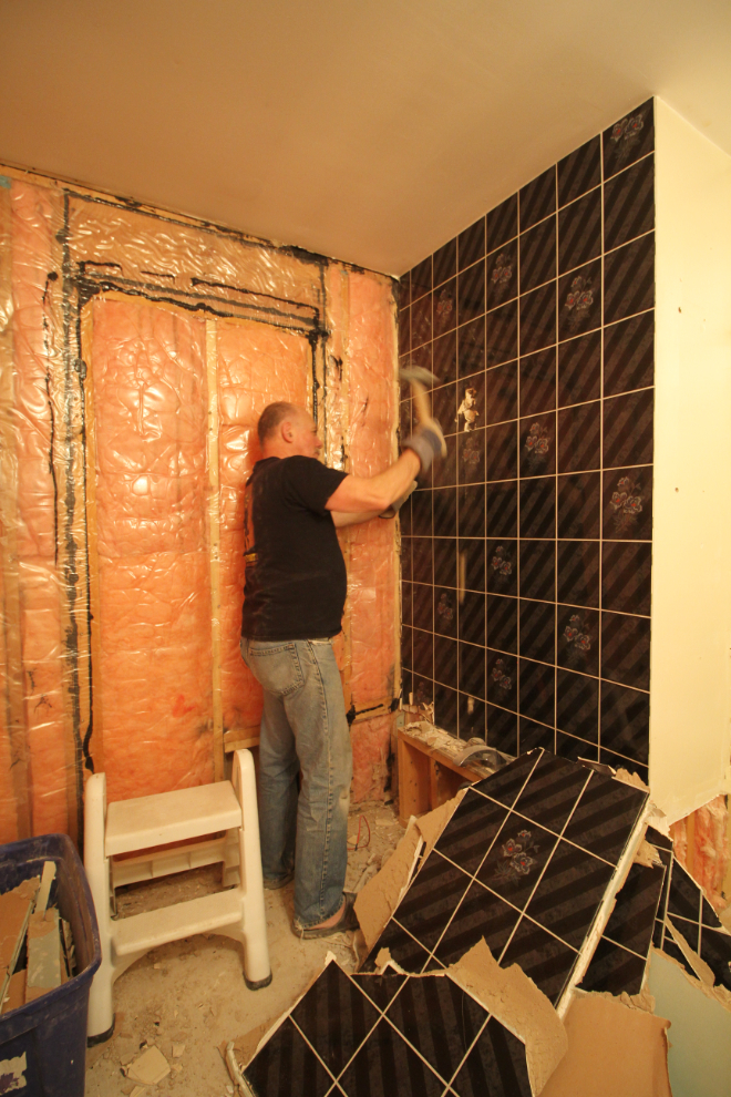 Removing bathroom tiles with a sledge hammer