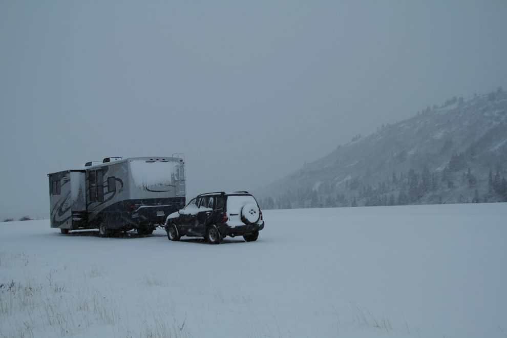 Snow-covered RV parked along the snowy Haines Highway in April