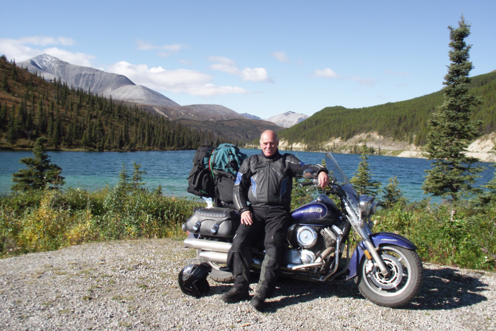 Murray Lundberg with his motorcycle along the Alaska Highway at Summit Lake, BC