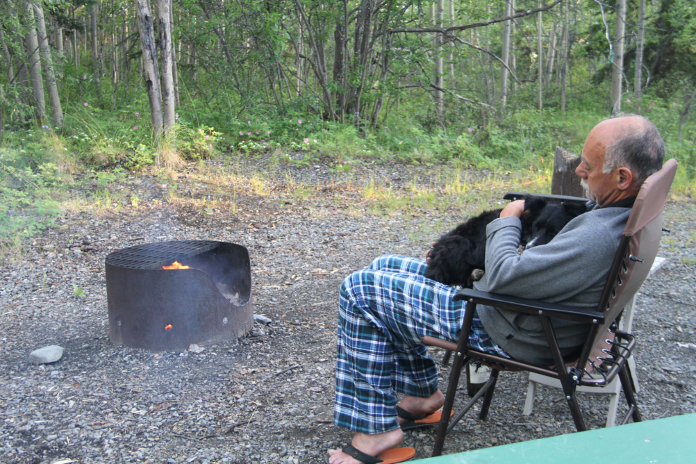 Snuggling with a puppy in front of a campfire at Teslin Lake Campground, Yukon