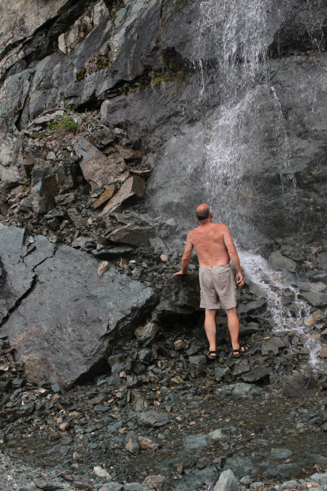 Taking a shower in a waterfall along the Granduc Road - Stewart, BC