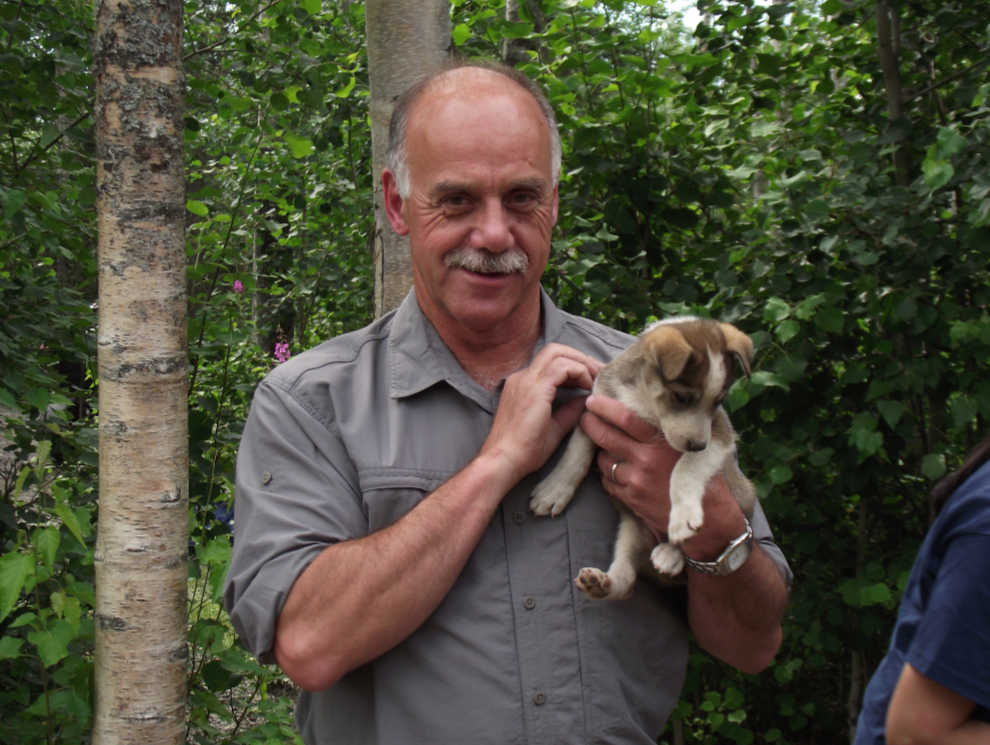 Tour guide Murray Lundberg with a husky puppy