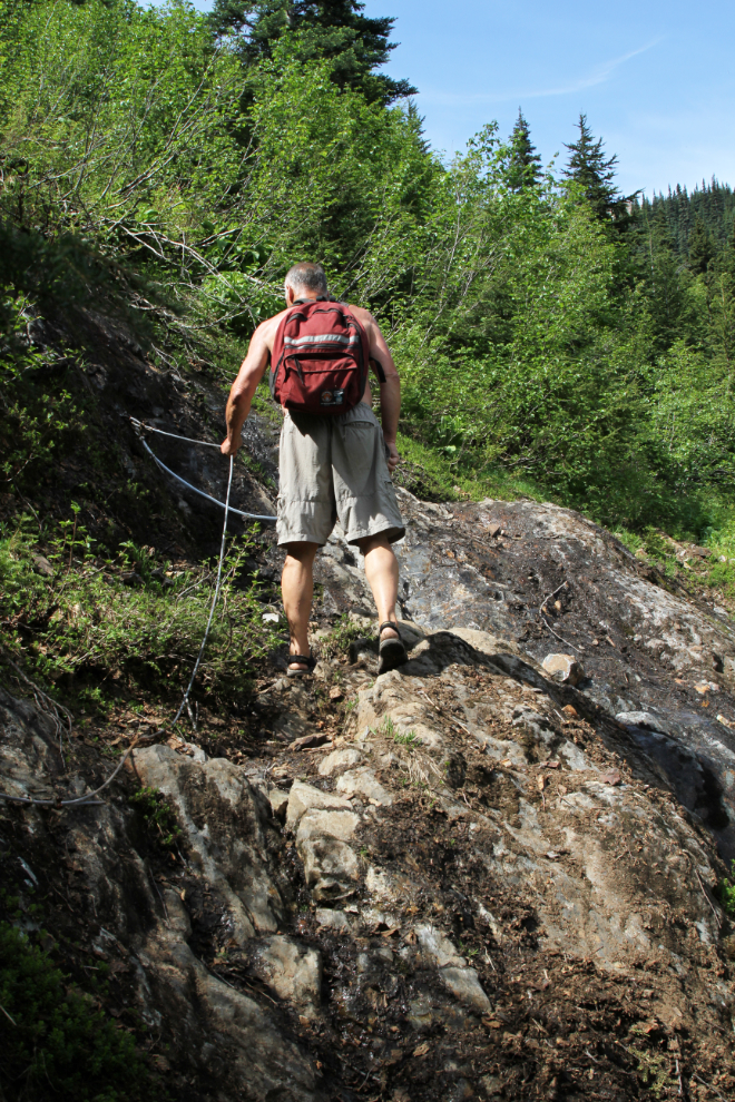 Hiker using a cable on the Glacier Gulch Trail at Smithers, BC