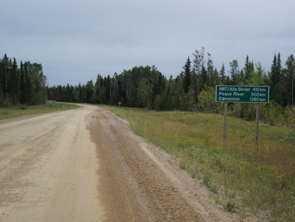 This gravel road is NWT Highway 1, the Mackenzie Highway - the sign notes that Edmonton is 1,380 km ahead!