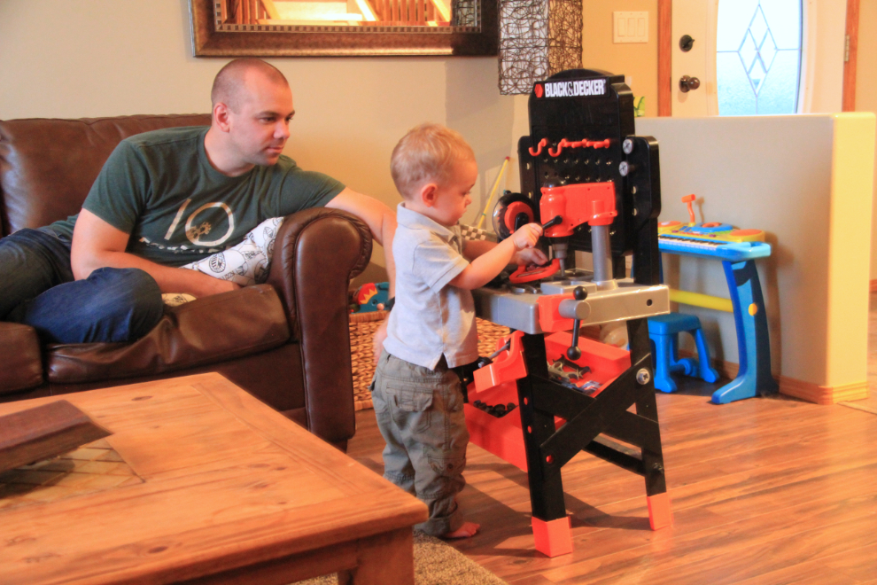 Father and son with a toy workbench