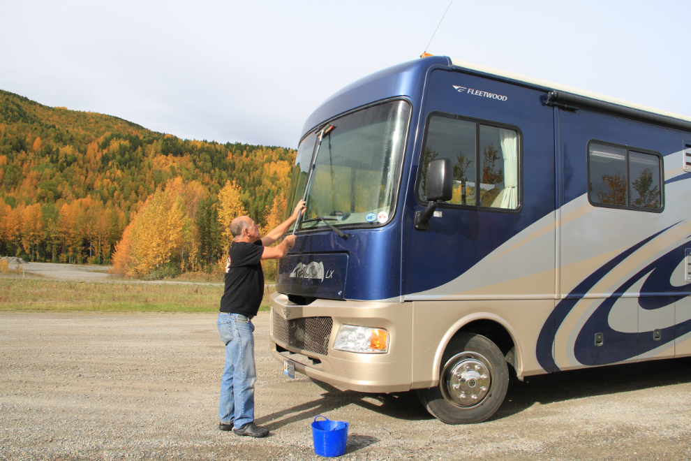 Cleaning an RV windshield along the Alaska Highway