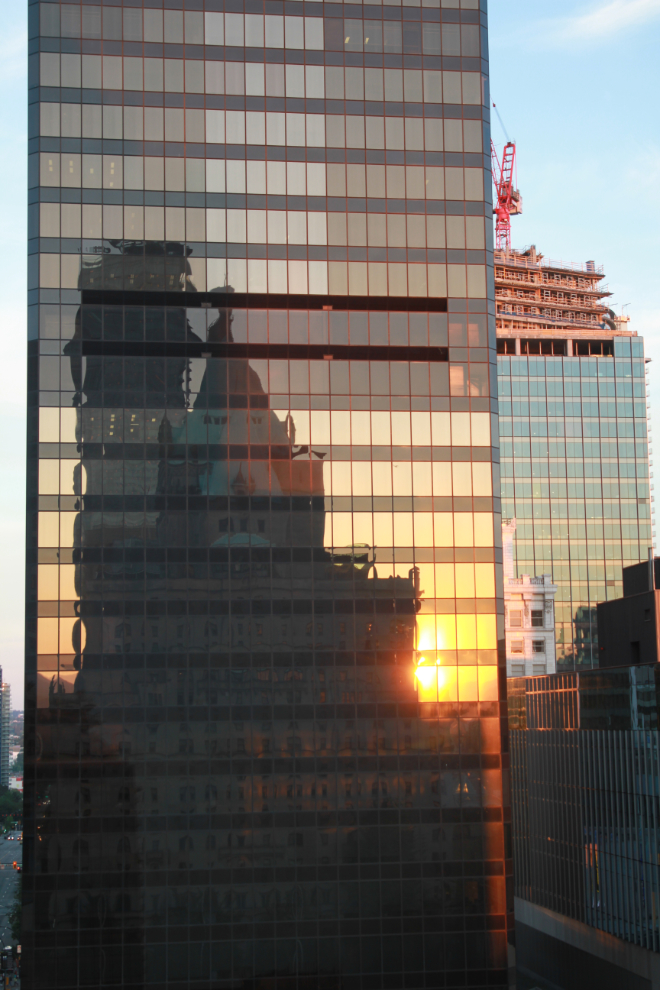 Reflection of the Hotel Vancouver and the setting sun in the windows of the TD Bank Tower.