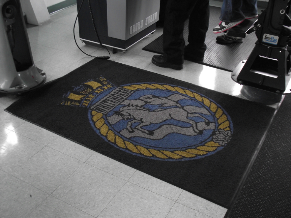 The ship's insignia on a carpet in the bridge on HMCS Whitehorse