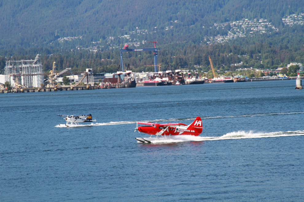 A couple of Harbour Air's float planes landing - Turbo Otter C-FODH in the foreground and Beaver C-FEBE behind it.