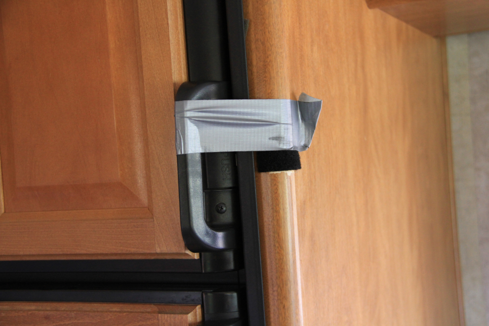 Duct tape holding an RV freezer door shut.