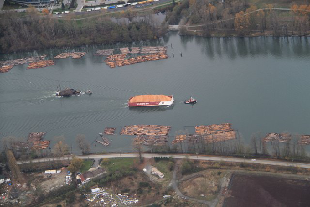 Sawdust and raw logs being towed up the Fraser River