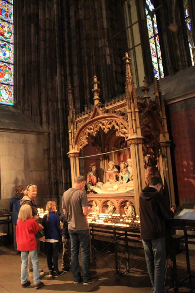 Lighting candles at a side altar in the Cologne Cathedral - Cologne, Germany