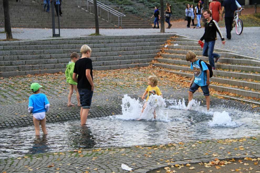 Boys playing in a water feature in Cologne, Germany
