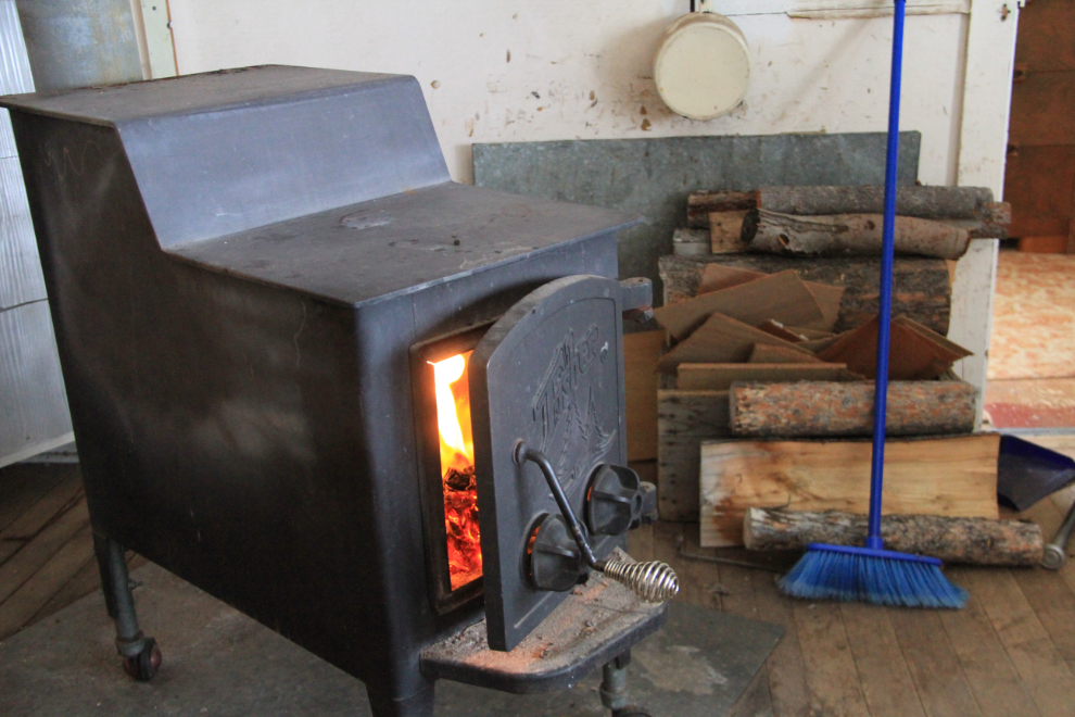 Lighting the woodstove in the Carcross cabin in the winter