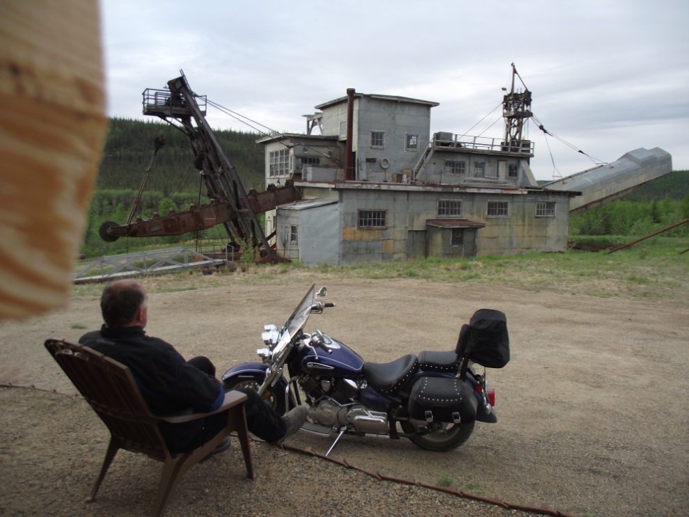 Murray Lundberg with his motorcycle and the Pedro gold dredge at Chicken, Alaska