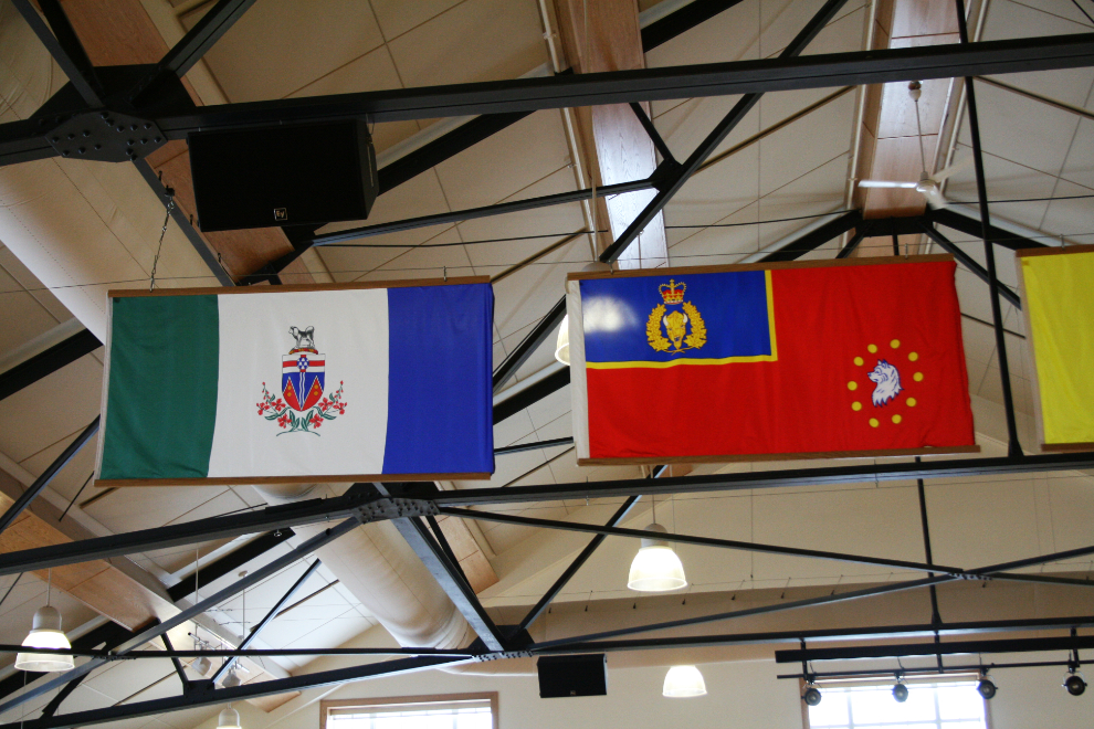 The Yukon and RCMP “M” Division flags hanging from the ceiling of the RCMP Depot Drill Hall.
