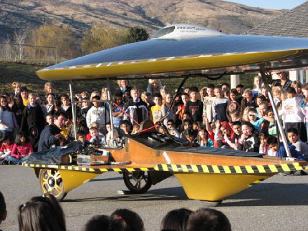 The Power of One (Xof1) solar car with a school class