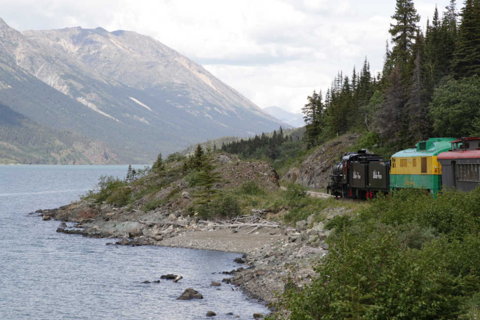 A WP&YR steam train along Lake Bennett, BC.