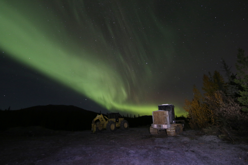 The Northern Lights over some logging equipment at Whitehorse, Yukon.