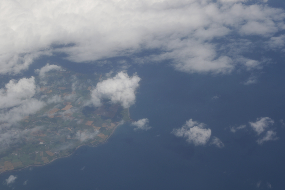 A glimpse of the coast of Ireland through clouds, from 37,000 feet.