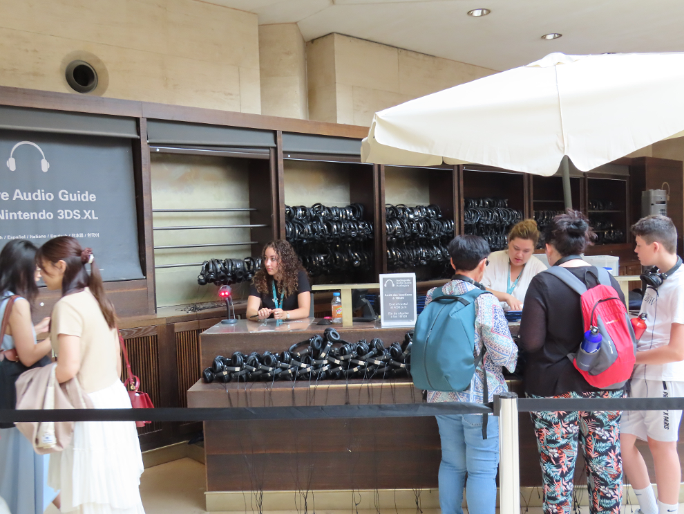 Piicking up very helpful audio guides  at the Louvre Museum in Paris.