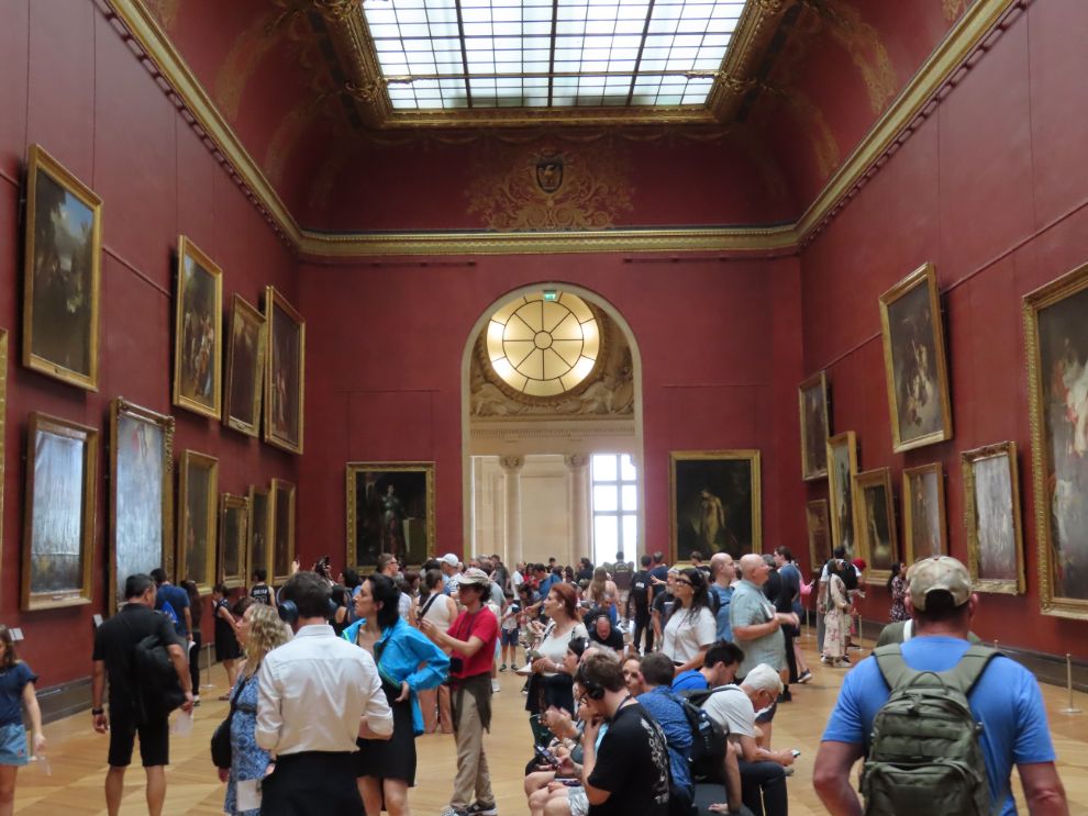 A room of grand paintings at the Louvre Museum in Paris.