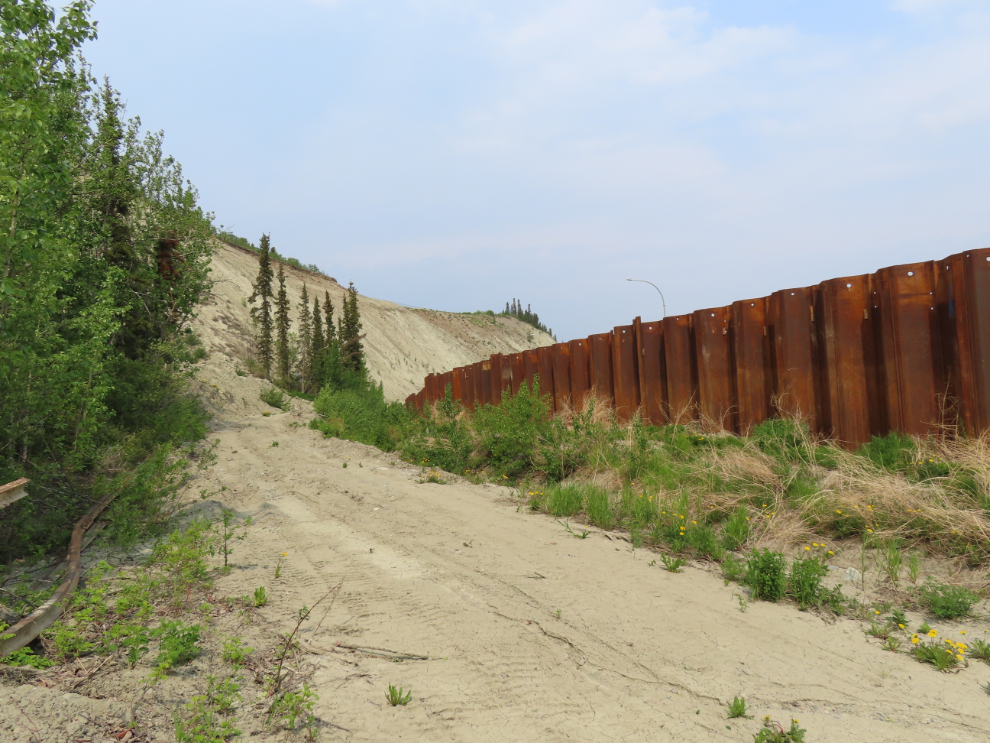 The metal sheet piling wall that was installed along Robert Service Way in 2022 as a slide barrier.