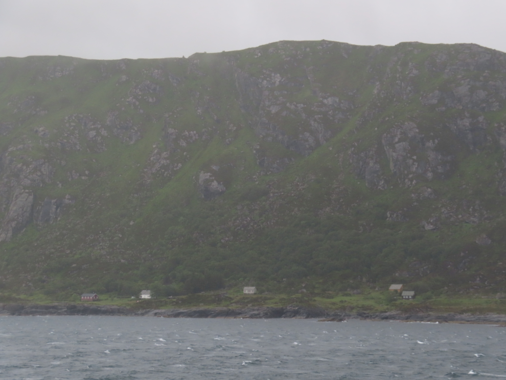 Houses on a rugged and remote part of the coast as we sailed towards Aldalsnes, Norway, on a stormy morning.