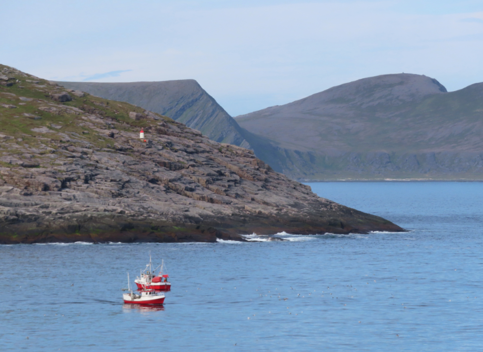 Fishboats and a little navigation light near Nordkapp (North Cape), Norway.