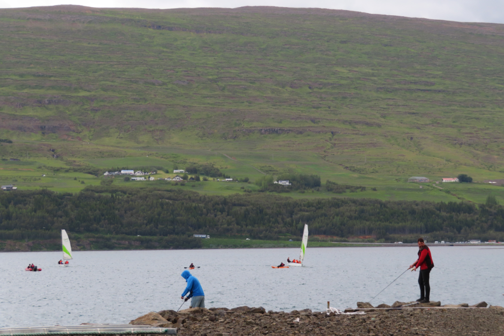 People fishing, kayaking and sailing at Akureyri, Iceland.