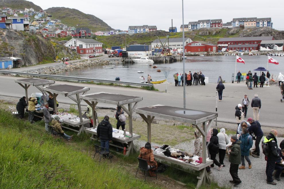 A multi-artist sale table set up by the dock at Qaqortoq, Greenland.