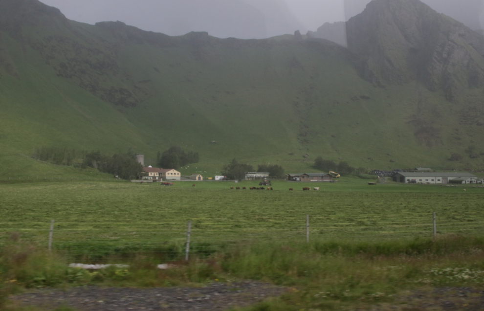 A farm below dramatic mountains along Iceland Route 1.