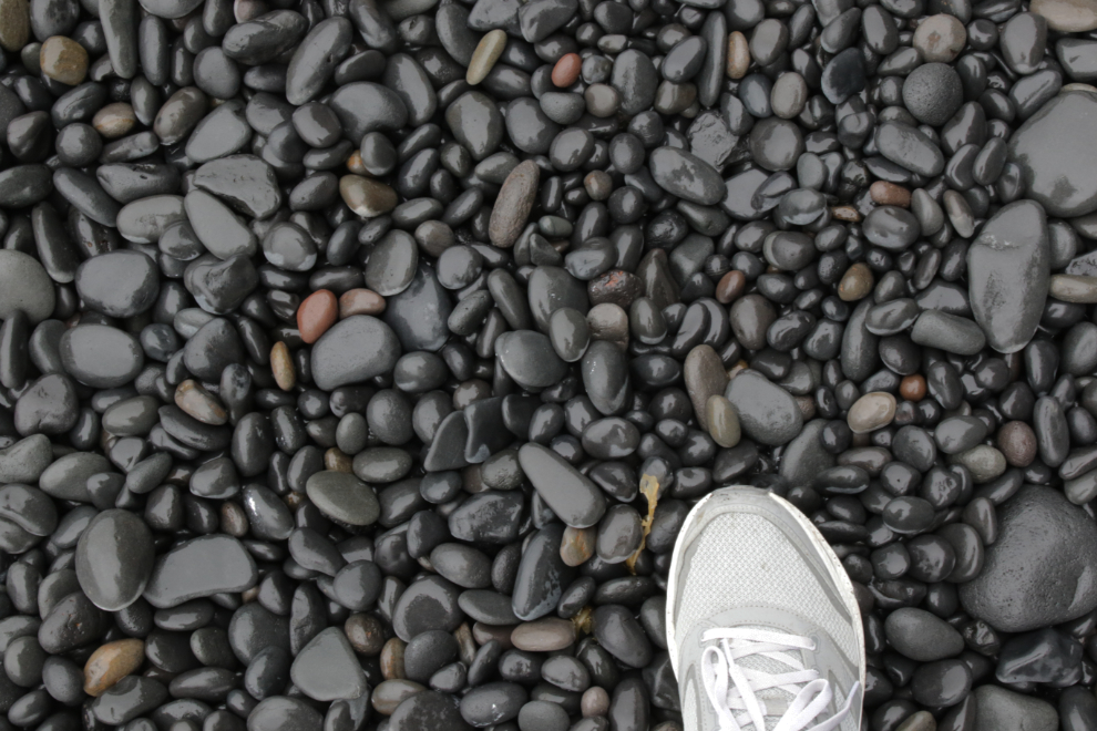 Polished black stones at Reynisfjara, Iceland, often termed a black sand beach.