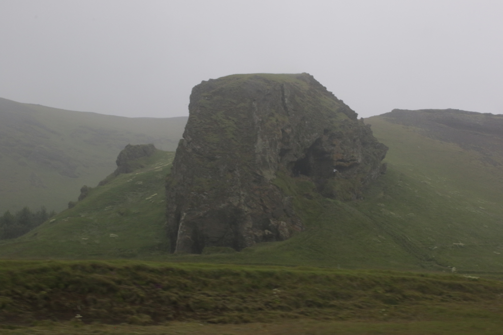 Climbing up a large volcanic formation on Iceland's South Coast, in heavy fog and volcanic smoke.