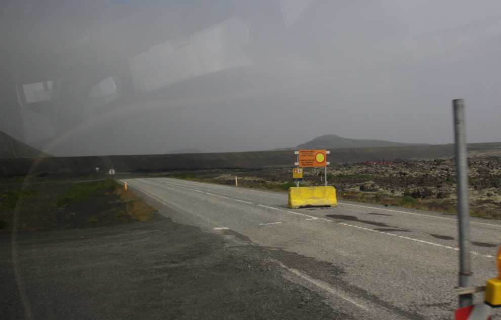 The former highway into Grindavik, Iceland, now blocked by a massive lava barrier, and lava behind it. 