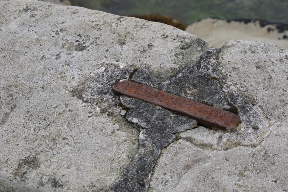 Heavy iron pins hold a seaside stone wall together at Lerwick, Shetland.