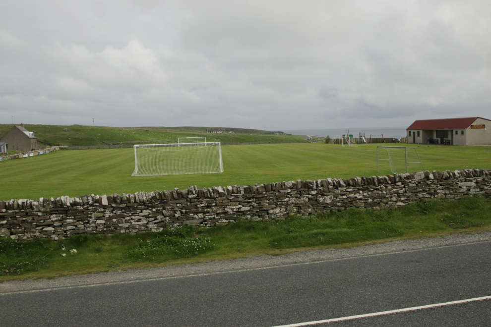 A playing field with a fine stone wall at Boddam, Shetland.