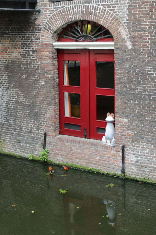 A whimsical window on a canal at Gouda, South Holland, the Netherlands.