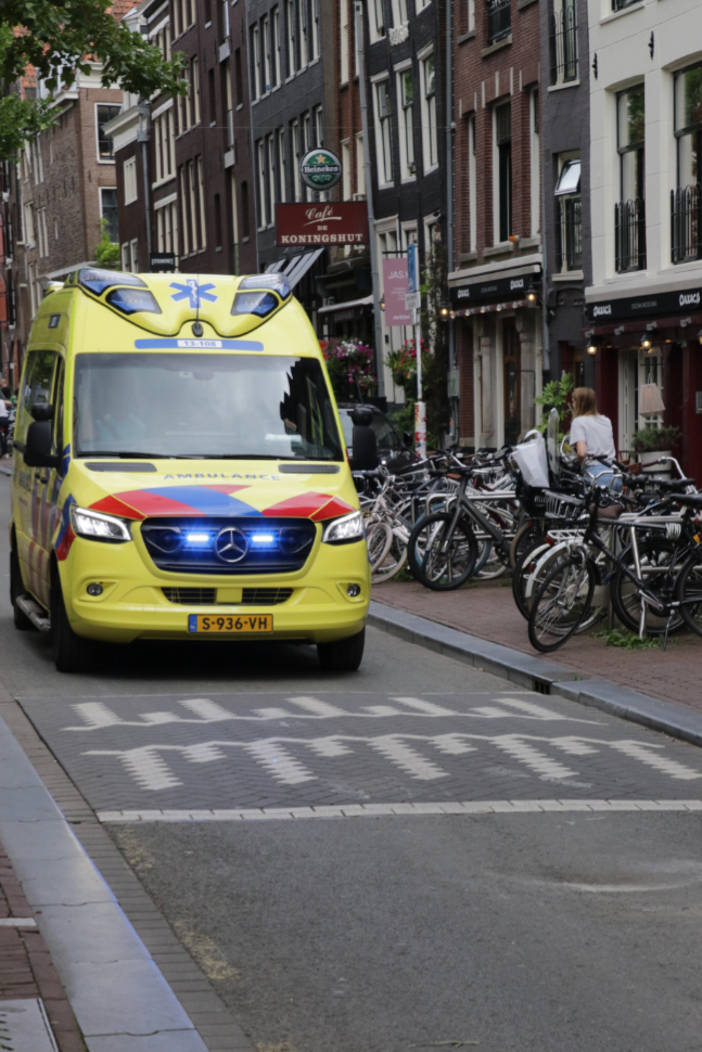 An ambulance coming down the street in Amsterdam.