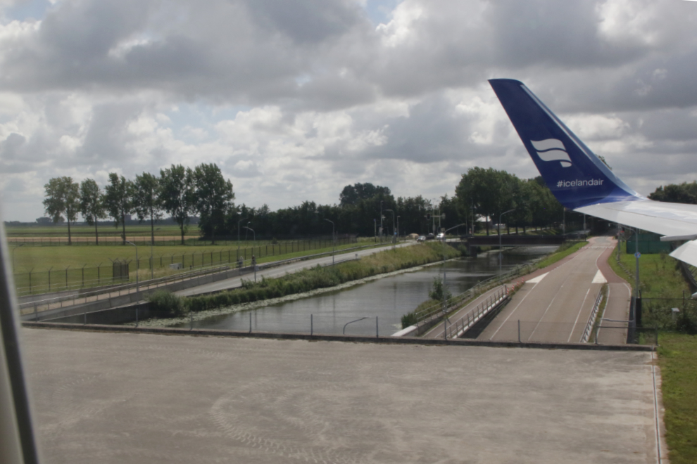 Taxiing over roads and a canal in an Icelandair Boeing 767 at Amsterdam Airport Schiphol (AMS).