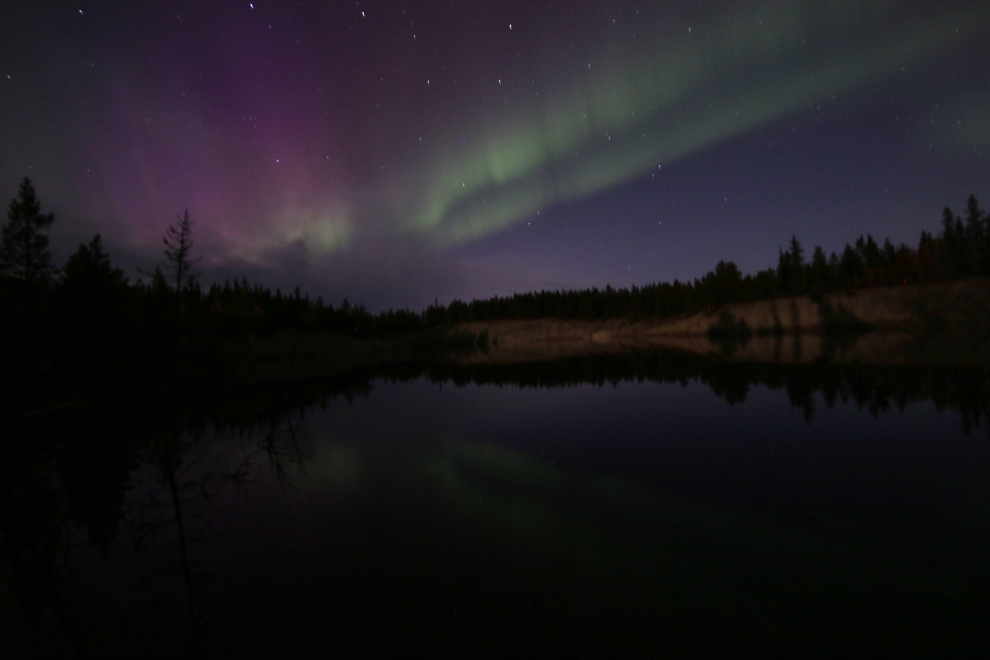 The aurora borealis over a flooded copper mining pit at Whitehorse, Yukon.