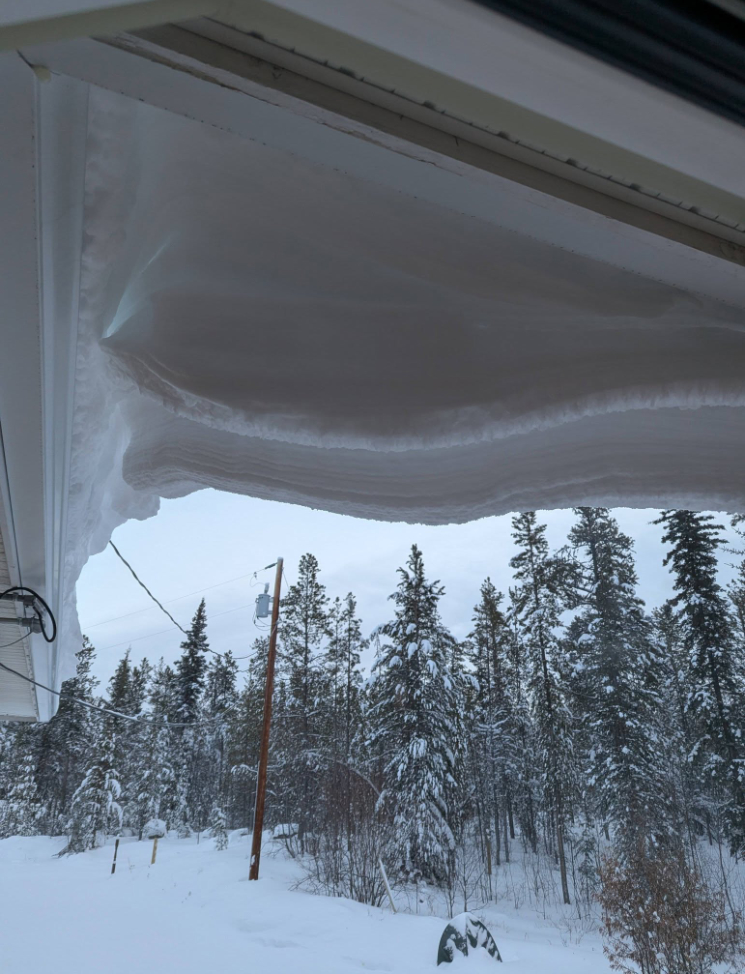 A massive overhang of snow on the roof.