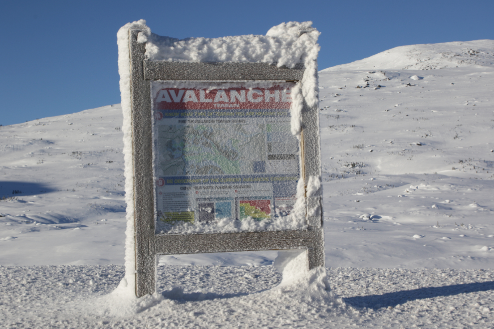 An avalanche warning sign in the White Pass with a thick coating of frost.