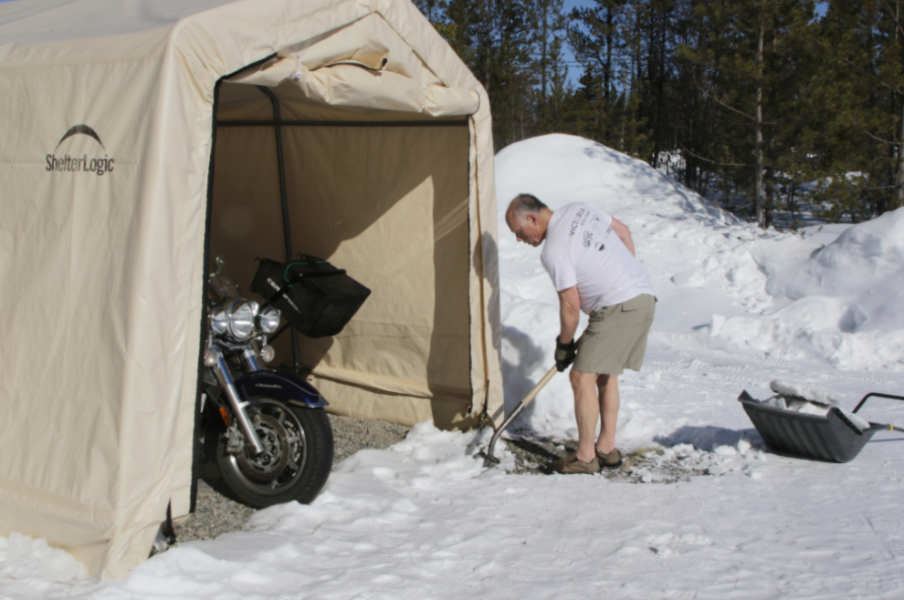 Murray Lundberg shovelling snow to get to the motorcycle in the Spring.