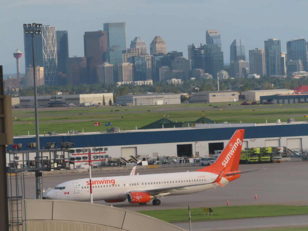 A Sunwing Boeing 737 with downtown Calgary behind.