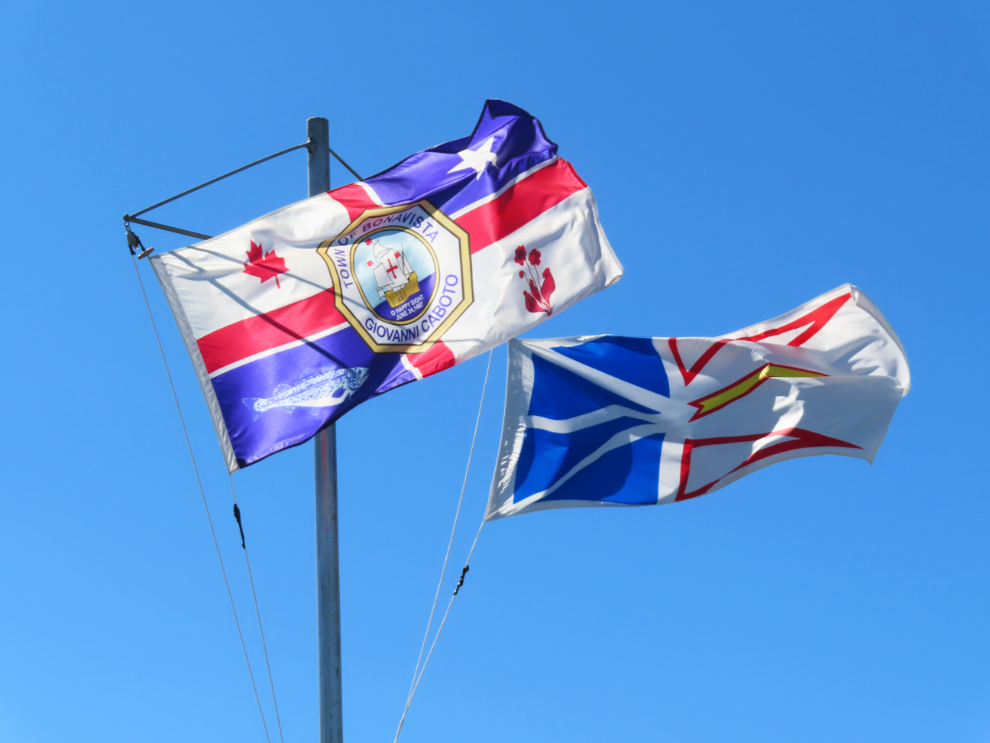 The flags of the Town of Bonavista and the province of Newfoundland and Labrador snapping proudly in the sunshine.